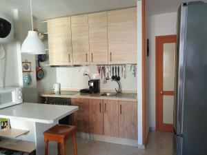 a kitchen with wooden cabinets and a white counter top at Cozy apartment near the ocean in Corralejo