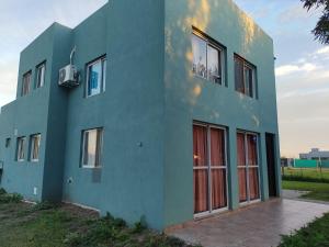 a blue building with red doors on the side of it at Mi casa en Lobos in Lobos