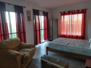 a bedroom with a bed and a couch and windows at Mi casa en Lobos in Lobos +17 photos
