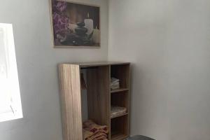una estantería de madera en una esquina de una habitación en Bel appartement de 40 M2 dans petite copropriété, en Le Coteau