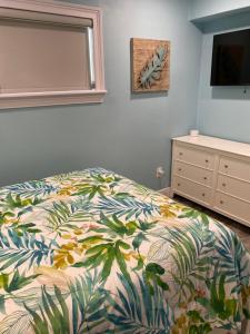 a bedroom with a bed and a dresser and a mirror at South Padre Island Beach House Retreat Downstairs in South Padre Island