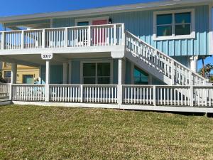 a house with a white railing and a porch at South Padre Island Beach House Retreat Downstairs in South Padre Island