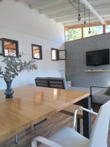 a dining room with a wooden table and chairs at Cabañas Tierra Kamiare 2 in Villa Amancay