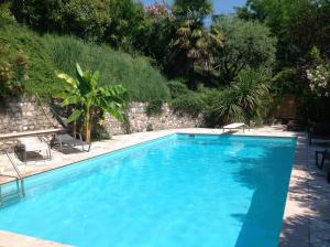 a large blue swimming pool with chairs and trees at B&B Villa Gardasee With Pool in Soiano del Lago