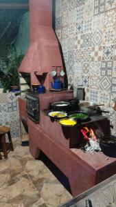 a kitchen with a stove with pots and pans at Casas em Ubatuba in Ubatuba