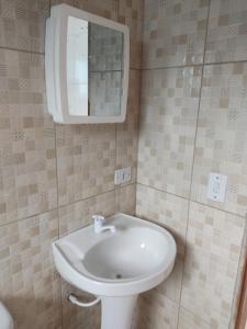 a bathroom with a white sink and a mirror at Casas em Ubatuba in Ubatuba