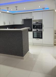 a kitchen with white cabinets and a black counter top at Lovely 2-Bed Apartment in Coventry in Coventry