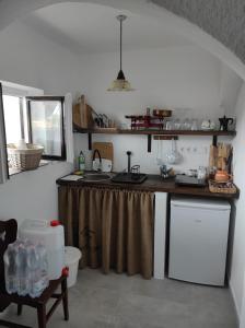 uma cozinha com um lavatório e uma bancada com uma bancada em Kisház a szőlőhegyen em Balatonakali