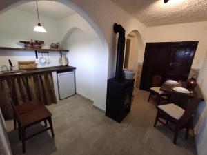 a kitchen with a stove and a table and chairs at Kisház a szőlőhegyen in Balatonakali