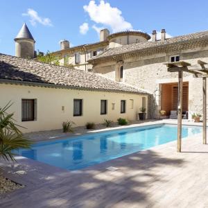 a villa with a swimming pool in front of a building at Gîte de l'orangerie du Château de la Bégude de Mazenc in La Bégude-de-Mazenc