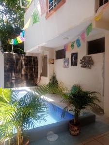 a house with a swimming pool and two palm trees at Hotel Familiar El Dorado in Zihuatanejo