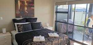 Un dormitorio con una cama con dos zapatos. en Waterways Renaissance "A Touch Of Class" en Whitianga