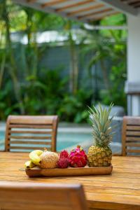 a plate of fruit on a wooden table at Peace Villa Santa Teresa - Walking distance to the beach in Santa Teresa Beach
