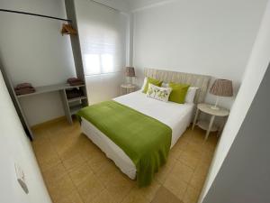 ein Schlafzimmer mit einem großen Bett mit grüner Bettwäsche in der Unterkunft Blue Beach House ATICO CON TERRAZA in Málaga