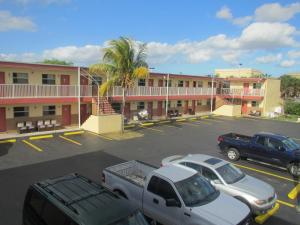 ein Parkplatz mit Autos vor dem Hotel in der Unterkunft Country Lodge in Florida City