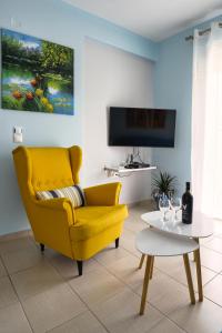 イオアニナにあるAmazing place in Pediniのリビングルーム(黄色のソファ、テーブル付)