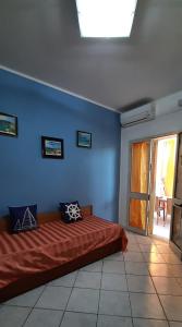 a bedroom with a bed with a blue wall at Case vacanze al mare di Lampedusa in Lampedusa