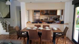 a kitchen and dining room with a wooden table and chairs at The Wind Sycamore Holiday Villas in Belek in Belek
