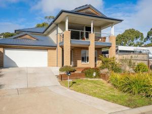 une maison en briques avec une porte de garage blanche dans l'établissement 21 Peninsula View, à Cowes