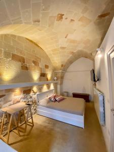 a bedroom with a bed and a stone wall at Musciu ti Lammia 2 in Manduria
