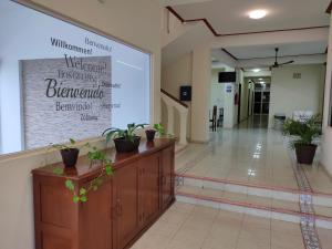 un grand écran de projection dans un couloir avec des plantes en pot dans l'établissement HOTEL CASA VEINTITRES, à Ciudad del Carmen