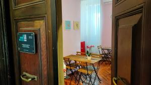 una stanza con tavolo e sedie, un tavolo e una porta di La Grande Bellezza Guest House Rome a Roma