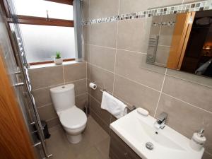bagno con servizi igienici, lavandino e specchio di All Seasons a Portrush