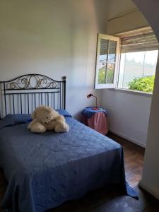 a teddy bear laying on a bed in a bedroom at varesse house in Mar del Plata