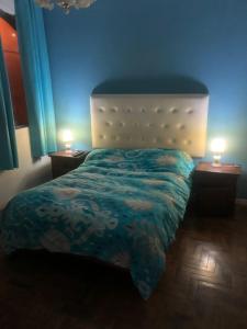 a bedroom with a bed and two lamps on tables at varesse house in Mar del Plata