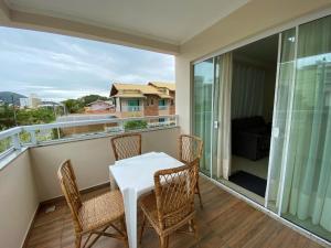 a balcony with a white table and chairs on it at Residencial Miguel in Bombinhas