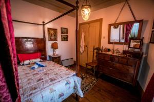 a bedroom with a bed and a dresser and a mirror at Solar dos Carvalhos in Sernancelhe