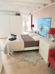 a bedroom with a large bed and a red chair at Dlo Coco in Les Abymes