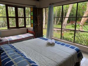 a bedroom with a bed with two towels on it at Solar das Mangueiras - Vale do Capão in Vale do Capao