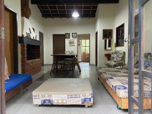 a living room with two beds and a table at Solar das Mangueiras - Vale do Capão in Vale do Capao