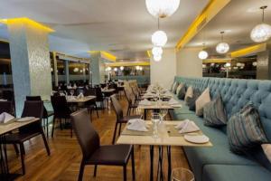 卡塔赫納的住宿－Exclusivo apartamento en Cartagena con vista al mar，餐厅设有蓝色的沙发和桌椅