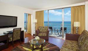 a living room with a television and a living room at Park Shore Waikiki in Honolulu