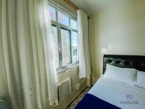 ein Schlafzimmer mit einem Bett und einem Fenster in der Unterkunft Ap ótima localização na praia do centro | ROFL01 in Rio das Ostras