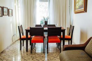 ein Esszimmer mit einem Tisch mit Stühlen und einem Fenster in der Unterkunft Ap ótima localização na praia do centro | ROFL01 in Rio das Ostras