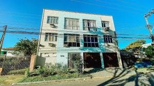 ein blau-weißes Gebäude am Straßenrand in der Unterkunft Ap ótima localização na praia do centro | ROFL01 in Rio das Ostras