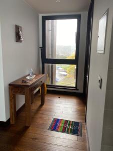 une pièce avec une table et une grande fenêtre dans l'établissement Alojamiento en La Puntilla de Villarrica, à Villarrica