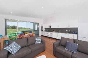 Una sala de estar con un sofá y una cocina. en Ocean Views 41, en Anna Bay