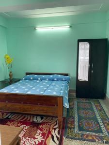 a bedroom with a bed and a door with a rug at B&B Homestay in Darjeeling