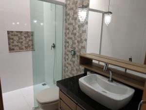 a bathroom with a sink and a toilet and a shower at Residência Cidade Verde 1, sinta-se em casa. in Maringá +30 photos