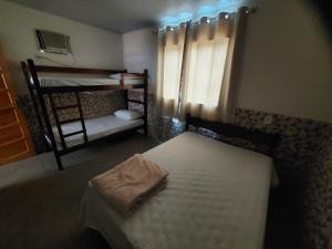 1 dormitorio con 1 cama y 1 litera con escalera en Pousada do Leô, en Mangaratiba