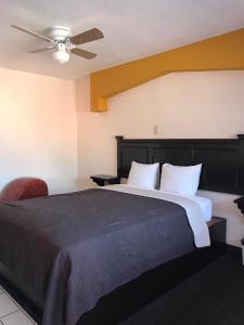 Schlafzimmer mit einem großen Bett und einem Deckenventilator in der Unterkunft COSTA MAR in Ensenada