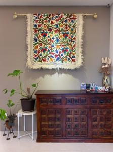 a tapestry hanging on a wall above a dresser at 像個家plus民宿 AT home plus B&B in Hualien City