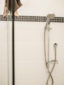 a shower with a shower head in a bathroom at Turnstone Beach House in Loorana