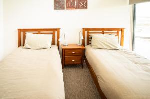 dos camas sentadas una al lado de la otra en un dormitorio en Turnstone Beach House en Loorana