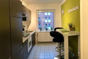 cocina con fregadero, nevera y ventana en Trade fair and business apartment - Hannover Messe, en Hannover