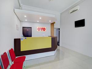 a lobby with red chairs and a vox booth at OYO Life 90570 Heboh Guest House Syariah in Ciwalengka